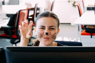Woman at the office masked as a cat for Halloween. Fun at the office
