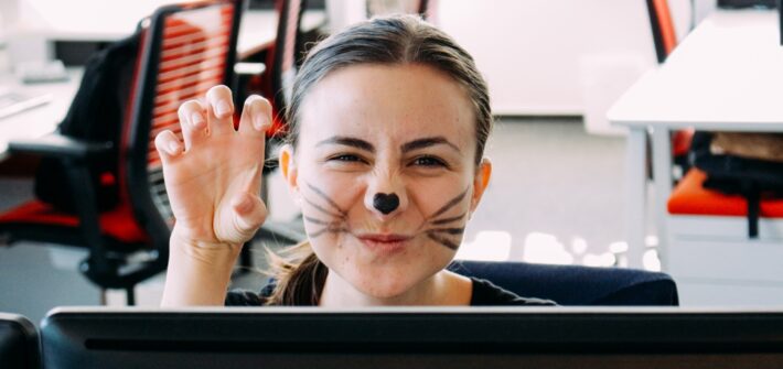 Woman at the office masked as a cat for Halloween. Fun at the office
