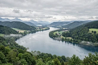 Vue panoramique du Danube serpentant à travers une vallée verdoyante d'Europe centrale, illustrant la longueur impressionnante du fleuve